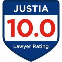 Shield-shaped badge with a blue border and white center displaying the text "Justia" at the top. Below, in large red numbers, "10.0" is shown, with the words "Lawyer Rating" in smaller blue text at the bottom.
